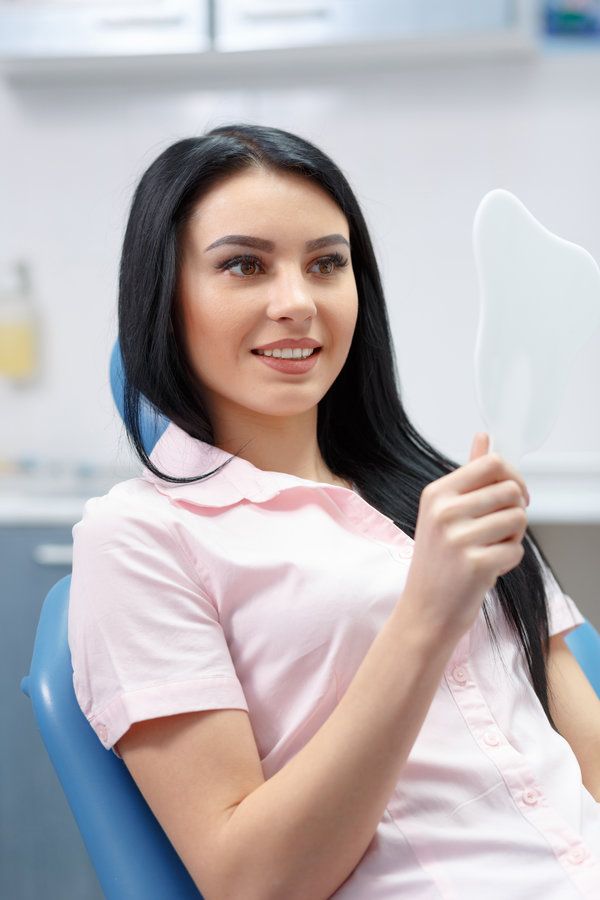 women watching in the mirror with her white teeth