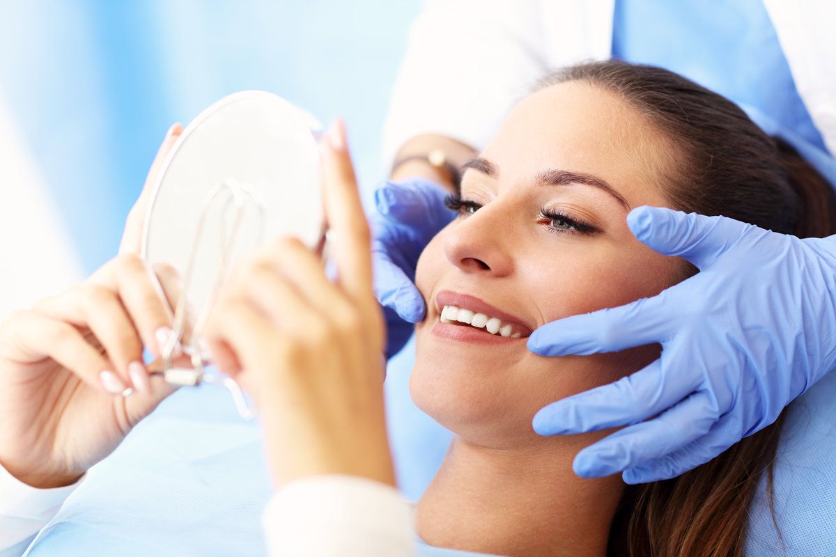 Patient admiring smile in dental chair