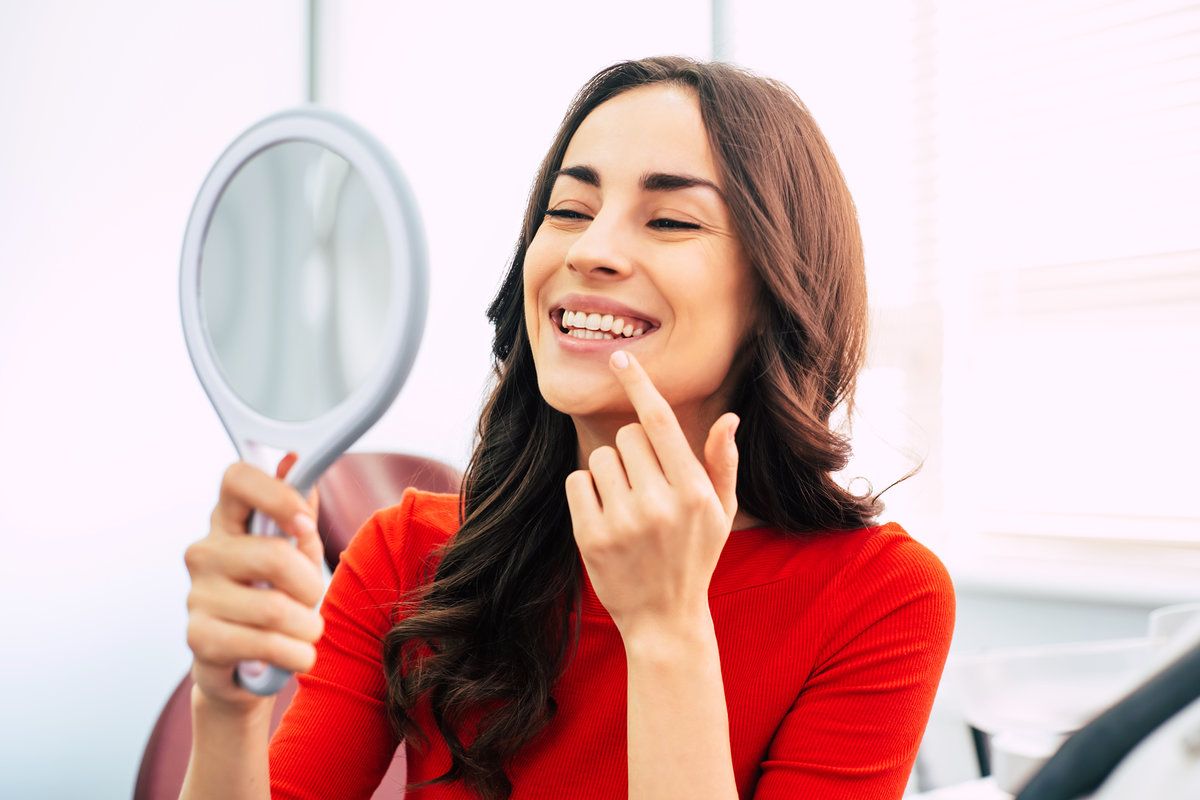 women smiling while holding the mirror