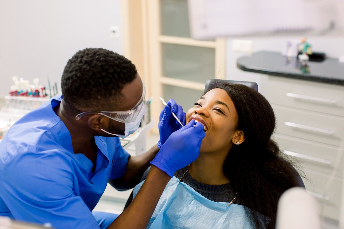 Dentist examining patient's teeth in clinic