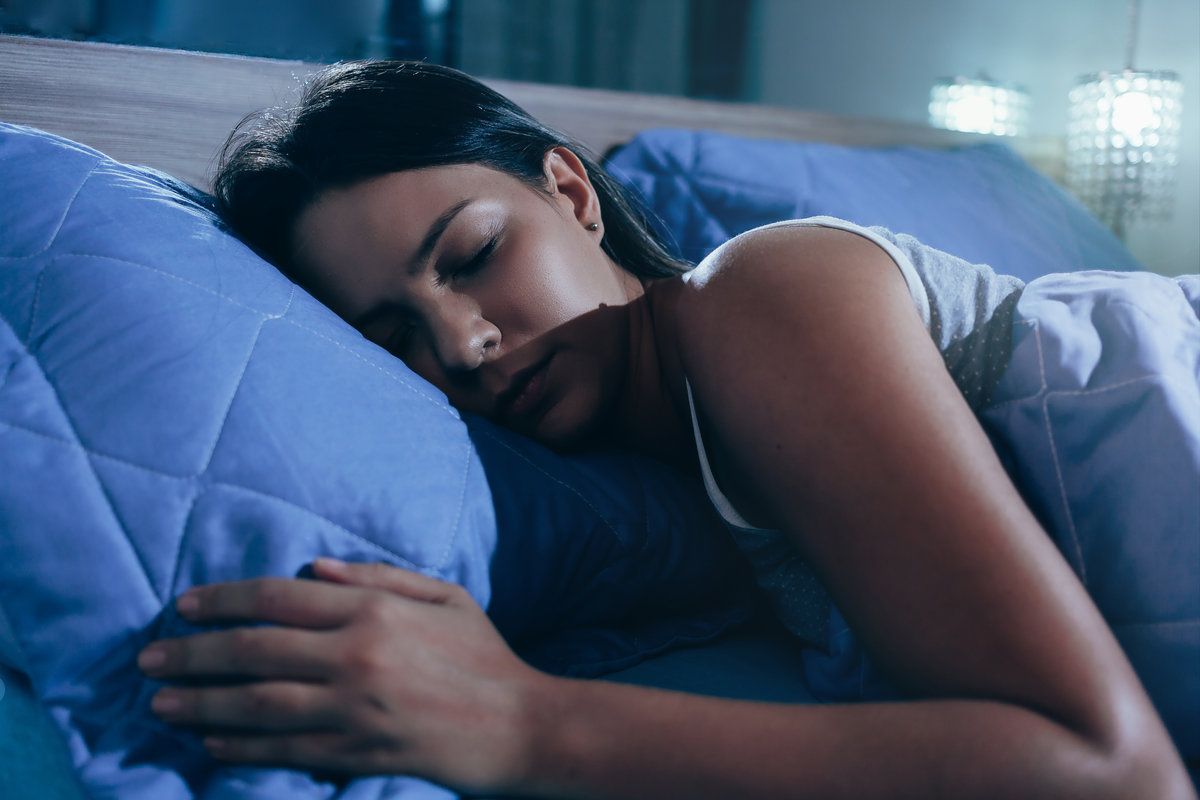 Woman peacefully sleeping on bed.
