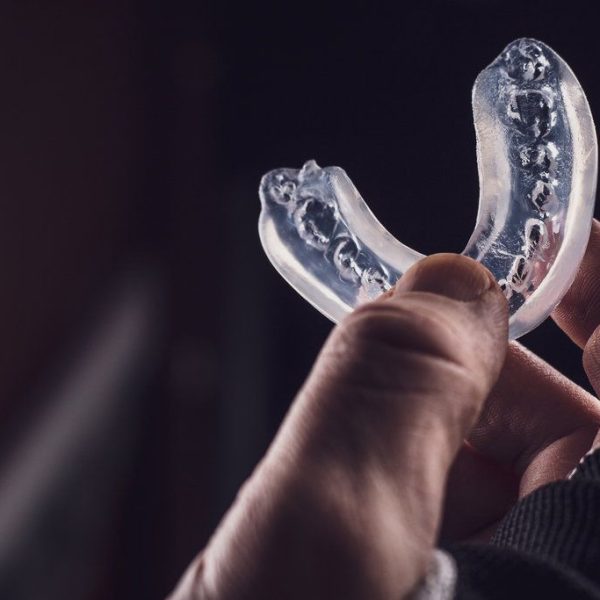 Hand holding a clear dental mouthguard