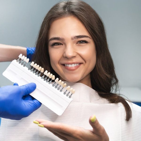 Smiling woman choosing dental shades.