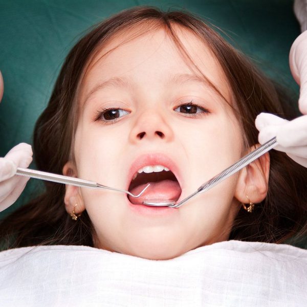 Child receiving dental examination and treatment