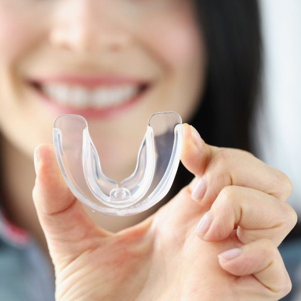 Hand holding a clear dental mouthguard